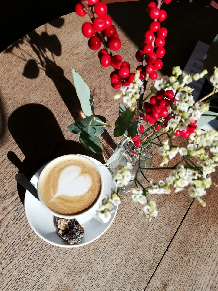 Latte Art und rote Winterbeeren