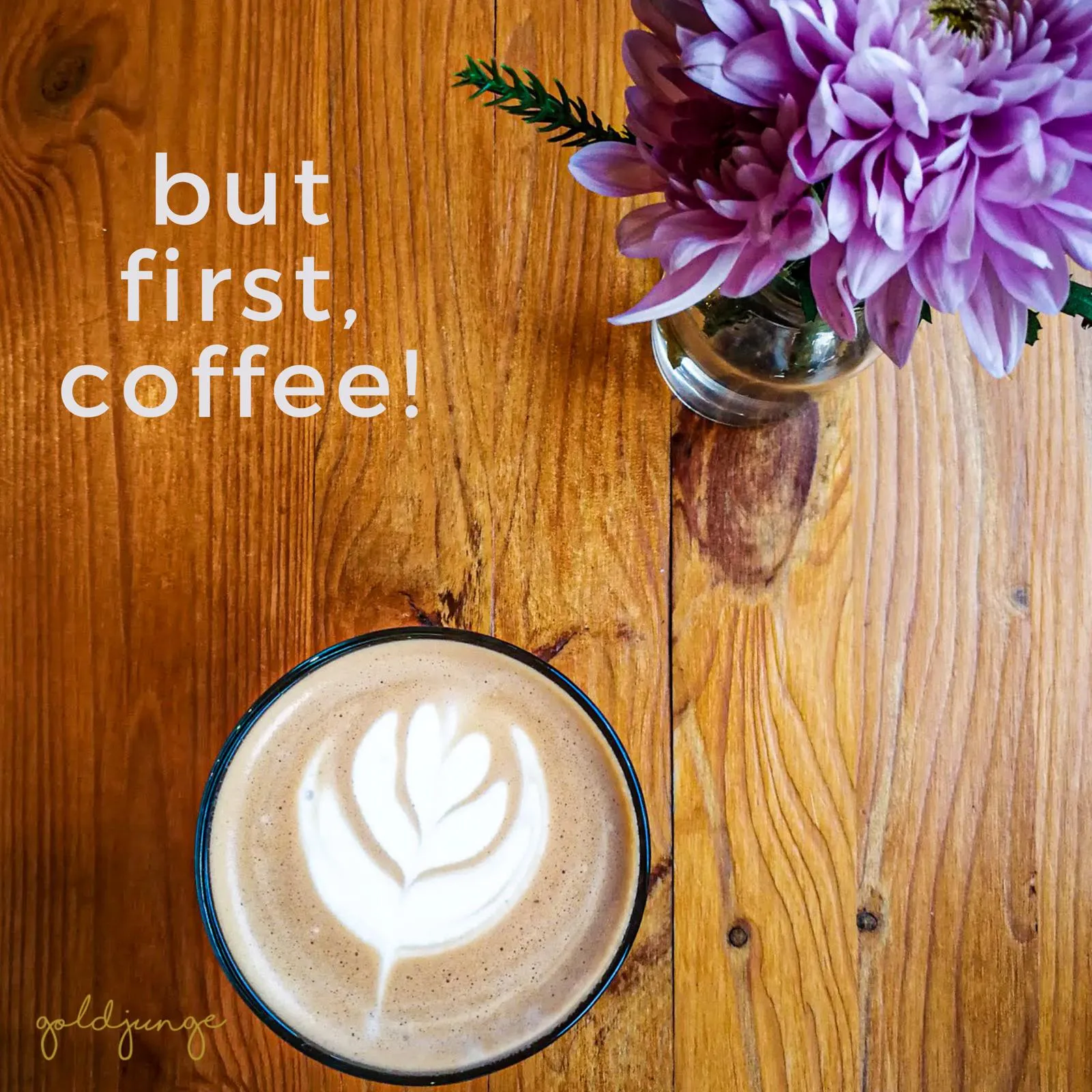 kreativ verzierter Kaffee auf Holztisch mit Blumen